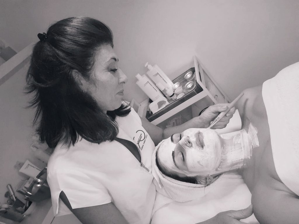 Fotografía en blanco y negro de Gemma Romero realizando un tratamiento en su Centro estético, Tomares.